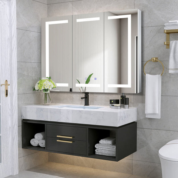 Modern bathroom with a large LED backlit mirror, marble vanity, black storage cabinet, and gold accents for a sleek look