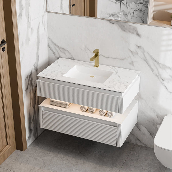 White bathroom vanity with marble countertop and gold faucet