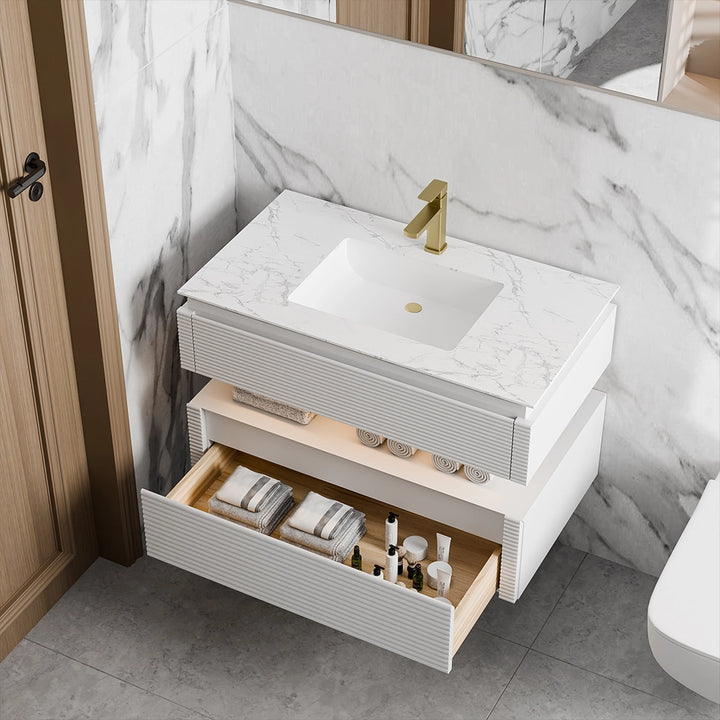 White bathroom vanity with open drawer and marble countertop