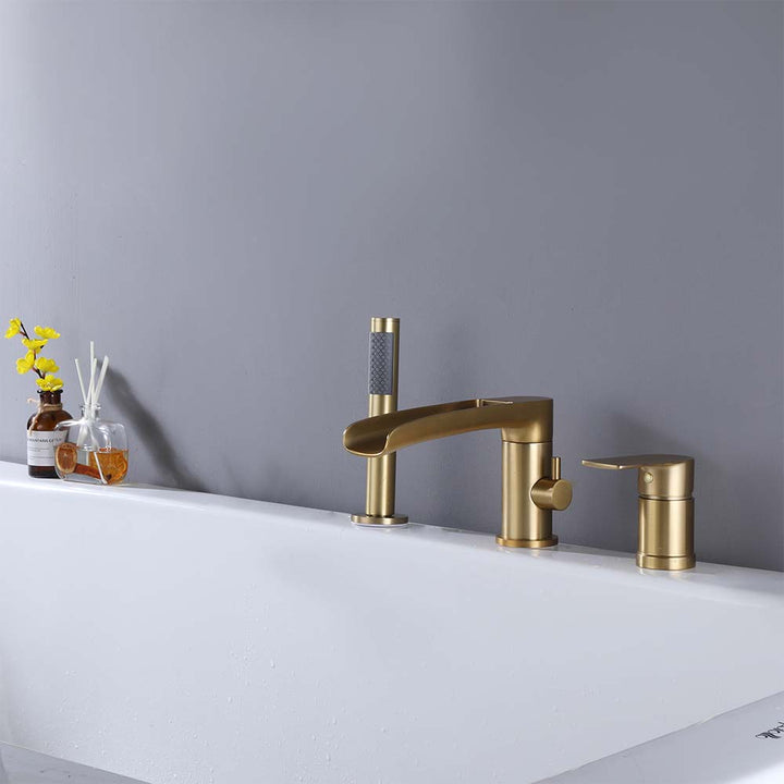 Gold bathtub faucet installed on tub with hand shower