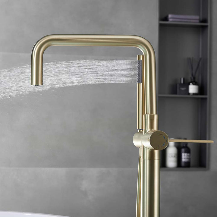Gold hand shower spraying water from side view