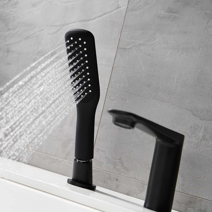 Hand shower spraying from modern black bathtub faucet