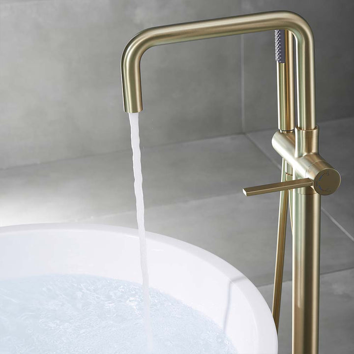 Gold square spout faucet filling bathtub with water
