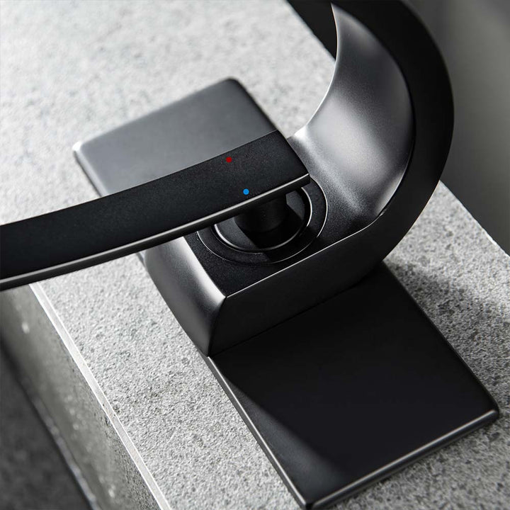 Black bathroom faucet handle with hot and cold indicator detail