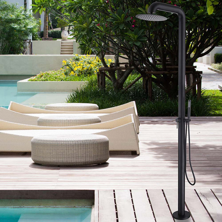 Black outdoor shower system beside pool and lounge chairs