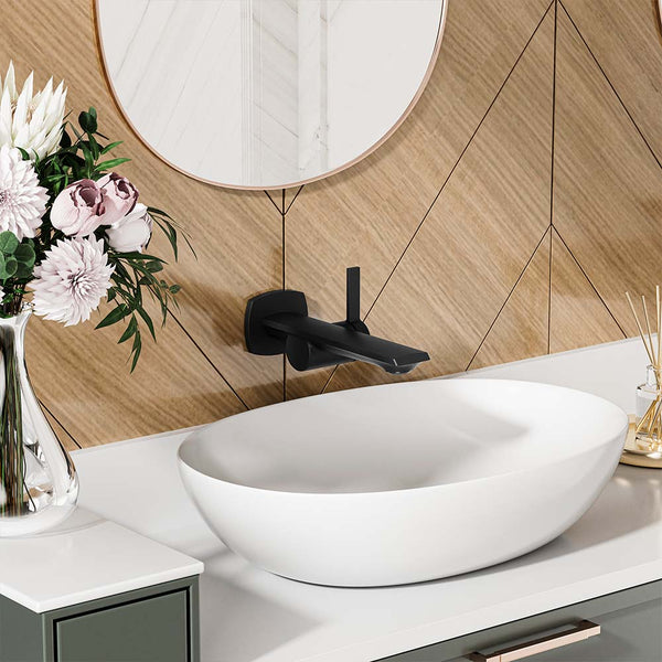 Black wall-mounted faucet above white vessel sink in modern bathroom.