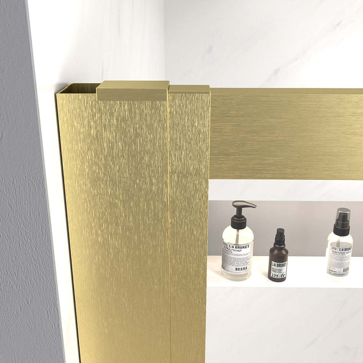 Close-up of brushed gold frame detail on shower door with clear glass and shelf.