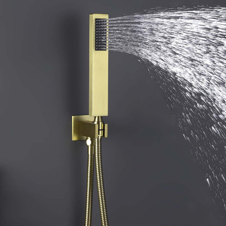 Brushed gold handheld shower spraying water against dark background