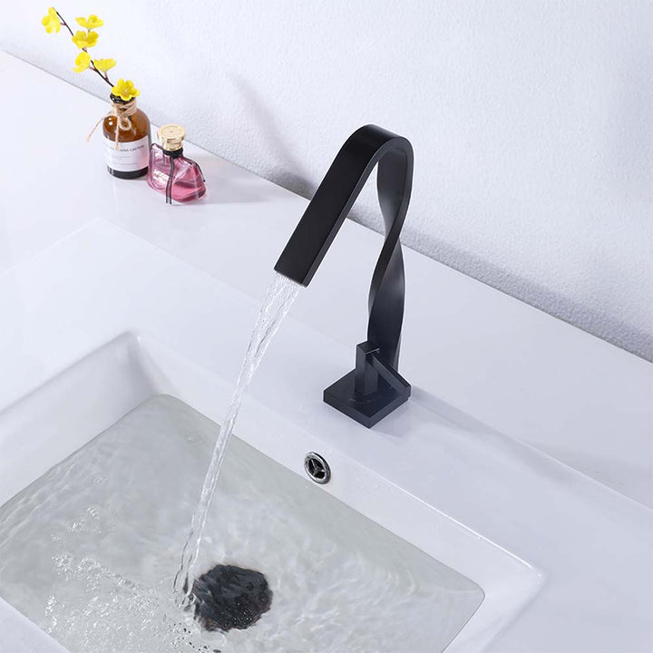 Modern black twisted spout faucet with water flowing into sink