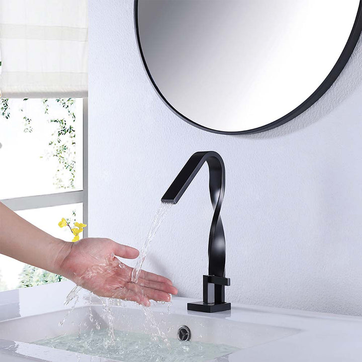 Modern black twisted faucet with hand under running water