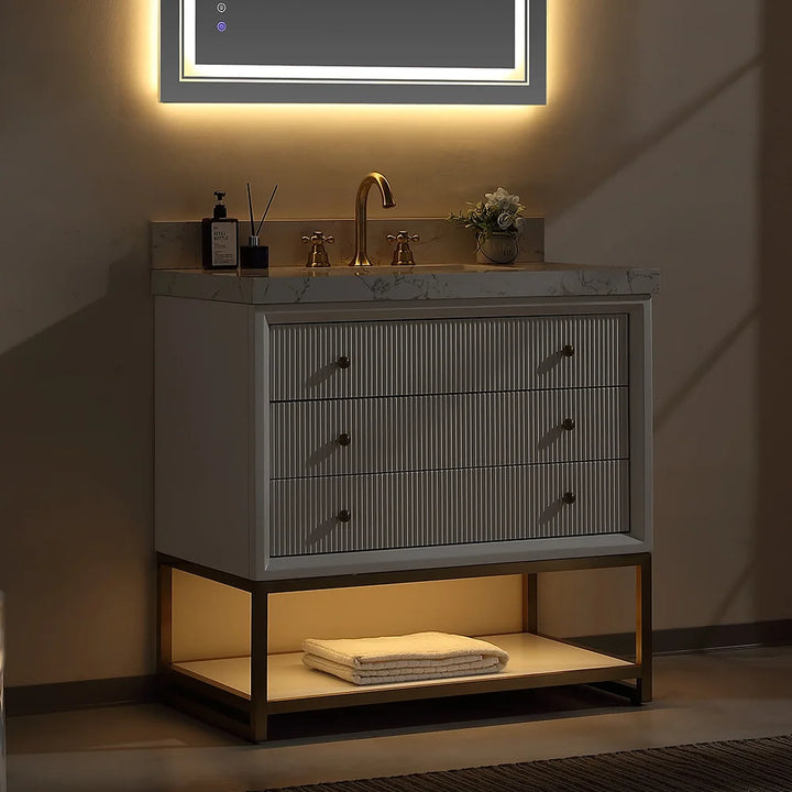 White fluted solid wood bathroom vanity with gold faucet under warm light