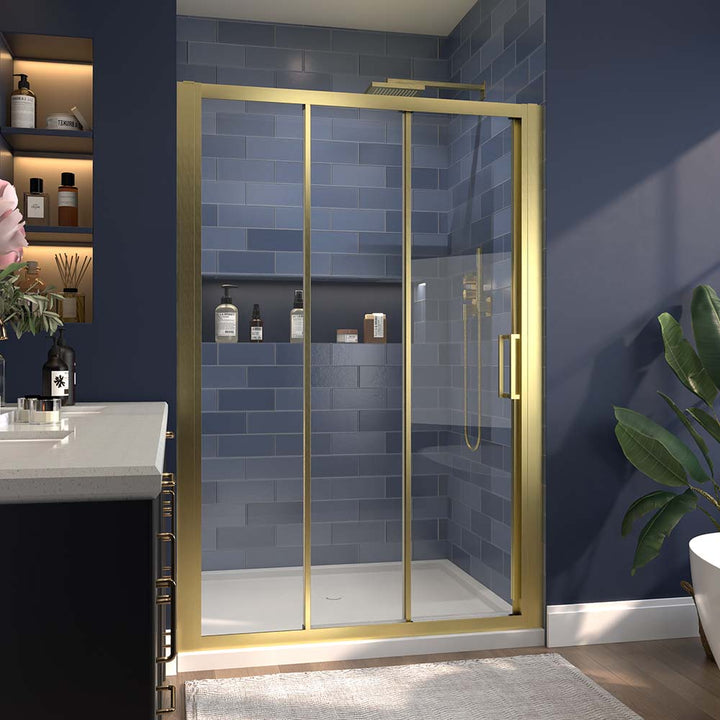 Gold-framed sliding shower door in a modern bathroom with blue tiles