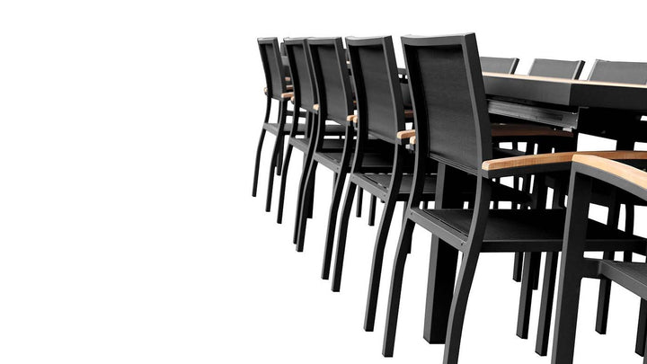 Side view of FSC teak outdoor dining set with 12 neatly arranged black armchairs