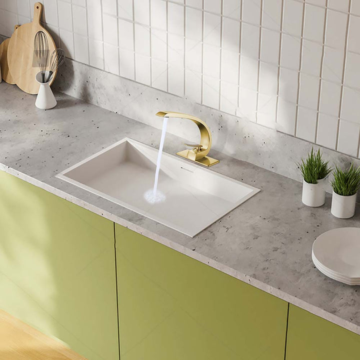 Modern gold bathroom faucet running water in white sink