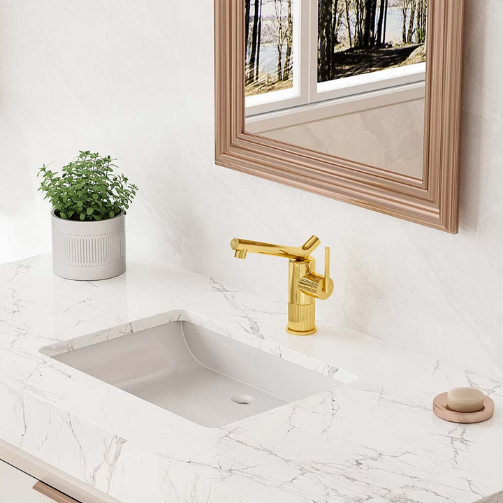 Close-up of gold bathroom faucet on marble vanity under mirror