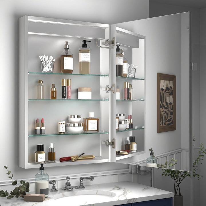 Bathroom LED medicine cabinet with glass shelves full of toiletries