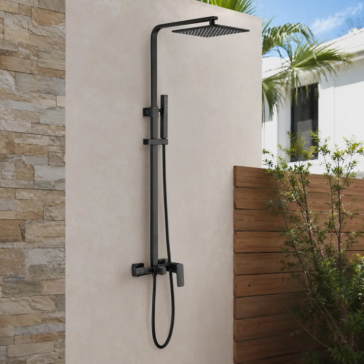 Matte black wall-mounted outdoor shower system with rainfall head and handheld sprayer installed on a modern patio wall