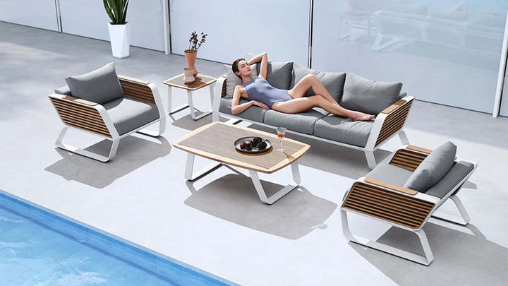 Modern aluminum and wood outdoor conversation set with gray cushions by the poolside