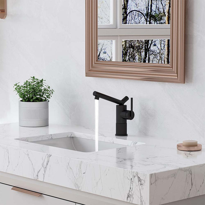 Black bathroom faucet with running water on marble vanity