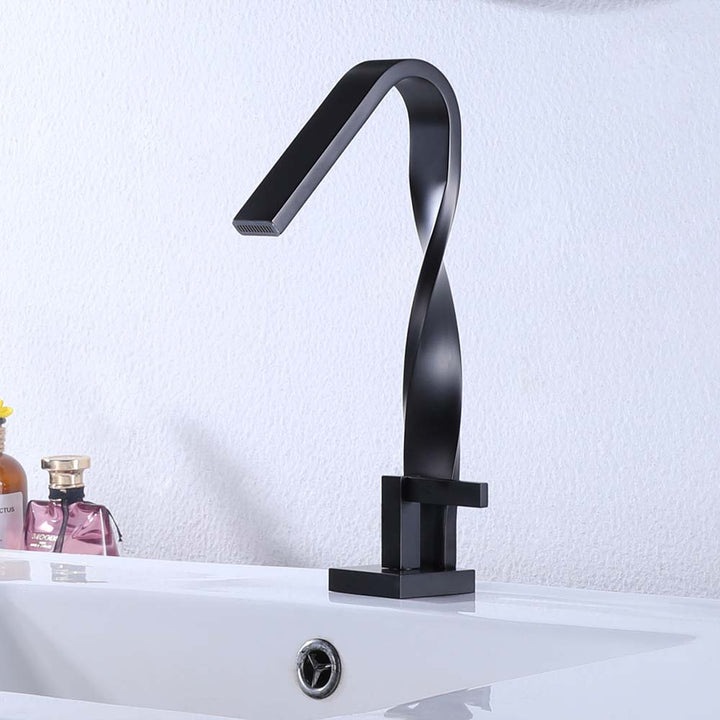 Modern twisted black faucet mounted on bathroom sink basin