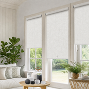 MODLAND P5 motorized roller shades in white above two sunlit living room windows.