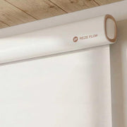 Close-up of a RezeFlow P7 motorized roller shade with a white cassette, rounded end cap and lowered fabric.