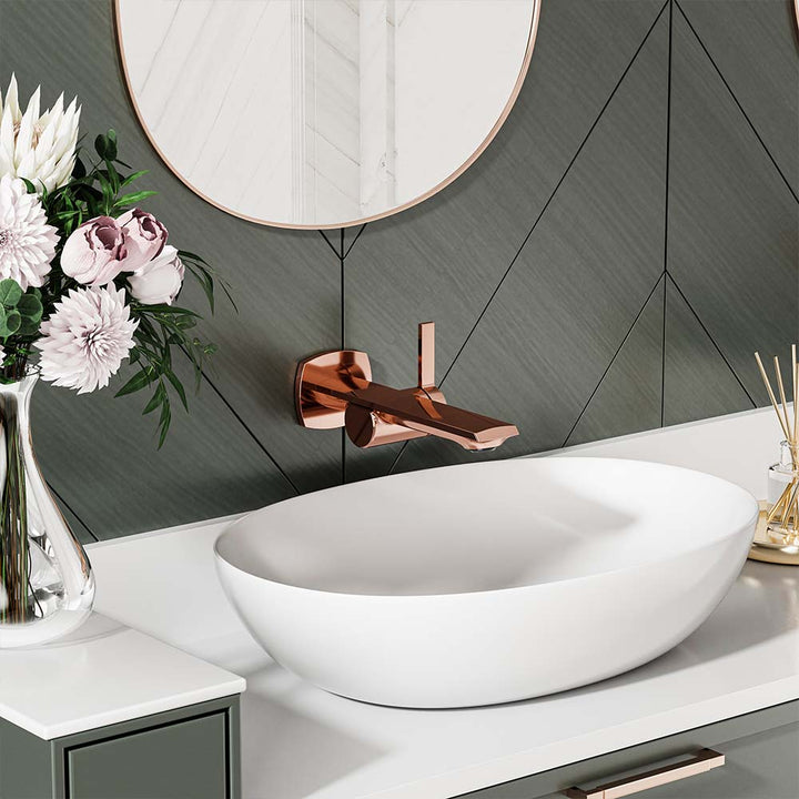 Close-up of rose gold faucet with white vessel sink in bathroom.