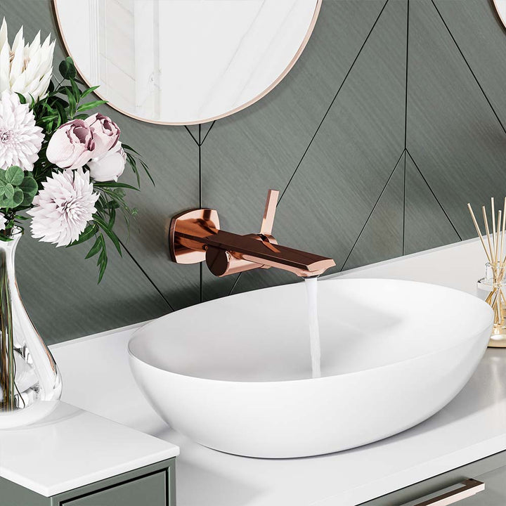 Rose gold faucet running water into vessel sink in modern bathroom.