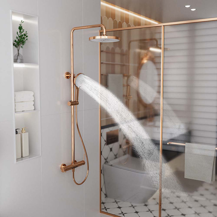 Rose gold shower system with handheld shower head spraying water