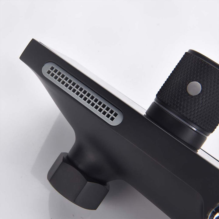 Close-up of matte black shower system diverter valve and outlet grille.