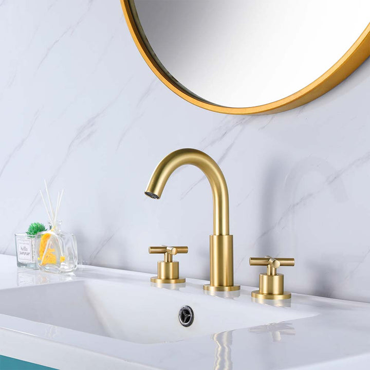 Gold bathroom faucet set with dual handles installed on vanity
