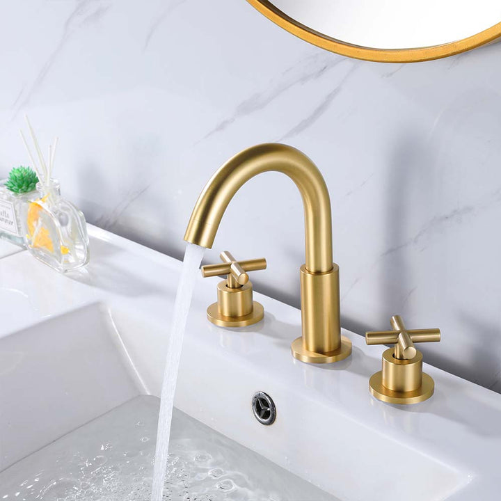Gold bathroom faucet with cross handles and running water flow