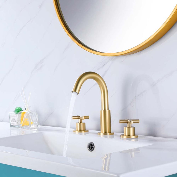 Gold bathroom faucet with running water on vanity sink