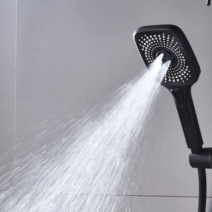 Handheld black shower head spraying water at high pressure.