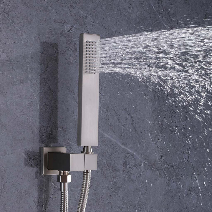 Handheld shower system spraying water flow on bathroom wall