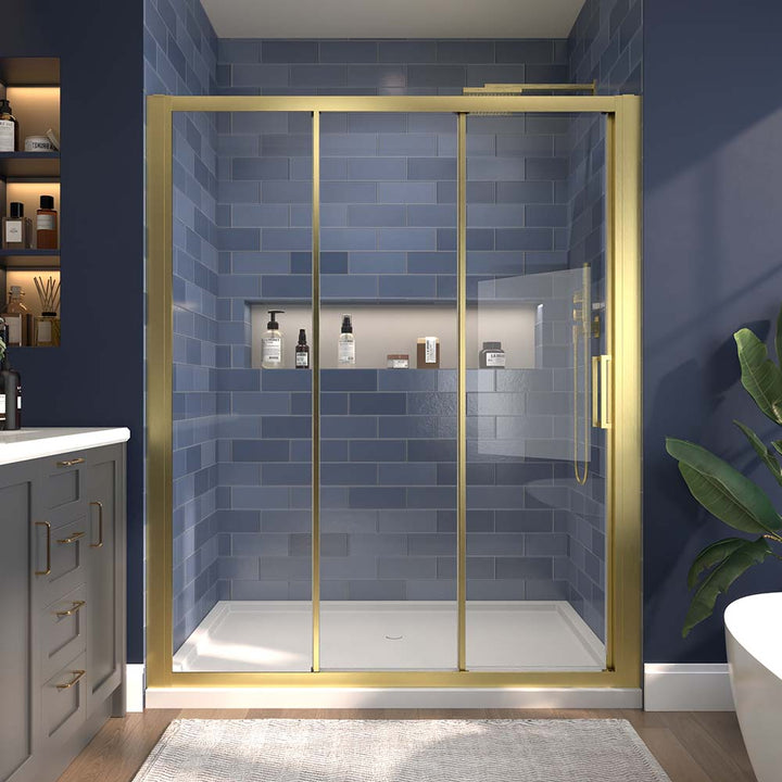 Gold-framed sliding shower door with clear glass and blue tiled wall background.