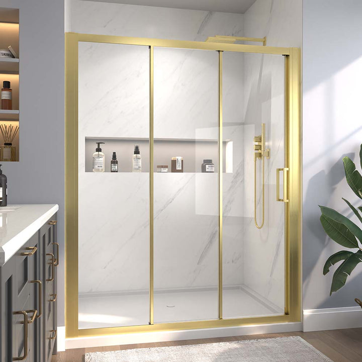 Gold-framed sliding shower door with built-in shelf and clear glass.