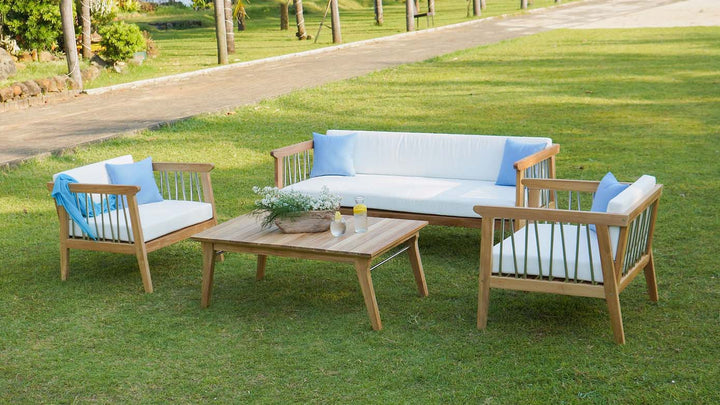 Teak patio 5-seat conversation set with white cushions and blue pillows by the beach