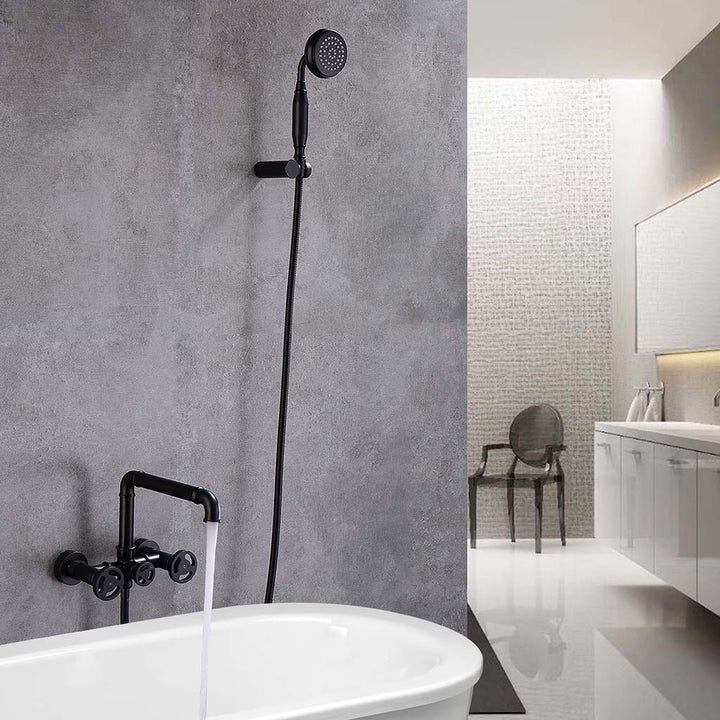 Black tub faucet with handheld shower, water flowing from faucet
