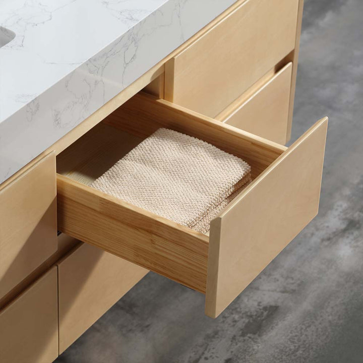 Wooden drawer with neatly folded towel in marble countertop vanity
